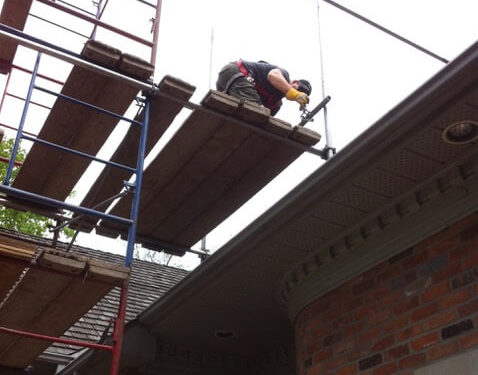 Repairman on scaffolding